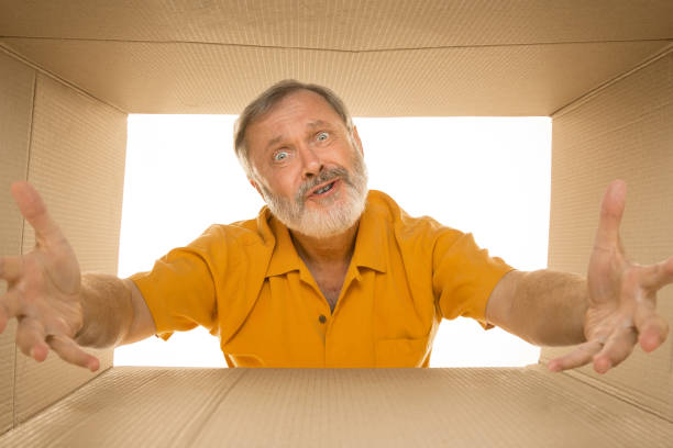 istock Senior man opening the biggest postal package isolated on white 1177407963