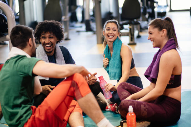 istock Young cheerful people resting from exercising at gym and communicating 1177408015