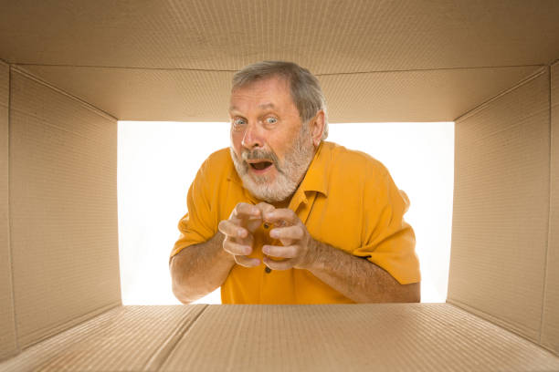 istock Senior man opening the biggest postal package isolated on white 1177408016