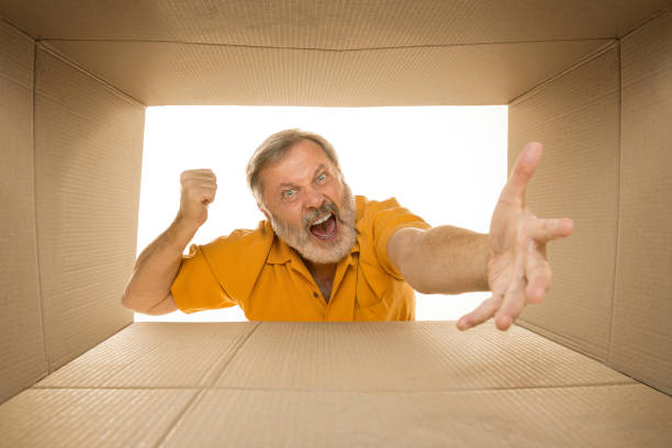 istock Senior man opening the biggest postal package isolated on white 1177408020