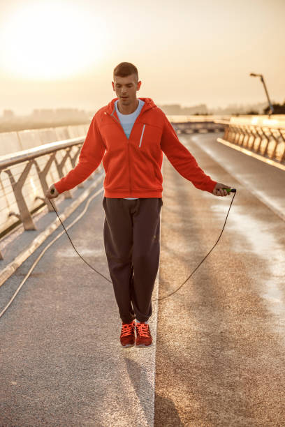 istock Focused fit young man jumping rope outdoors 1177410554