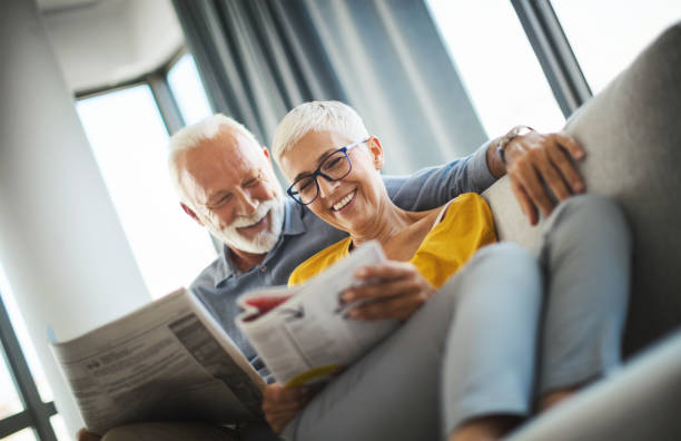 mature couple reading magazines together. - newspaper reading blank women imagens e fotografias de stock