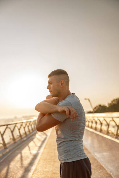 istock Professional young sportsman doing stretching exercises outside 1177413007