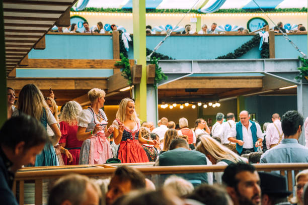 visitantes que comemoram oktoberfestfest na barraca da cerveja, munich, alemanha - lederhosen oktoberfest beer dancing - fotografias e filmes do acervo