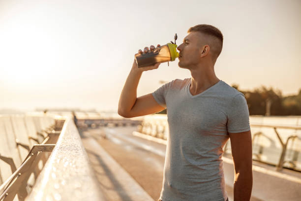 istock Handsome sportsman drinking water on a bridge 1177413203