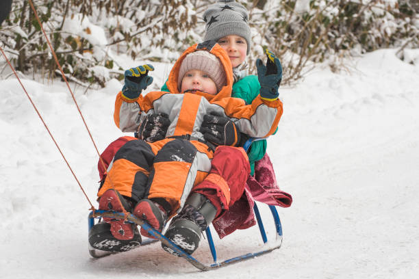 istock Two boys ride on a sled. Winter sunny day 1177416637