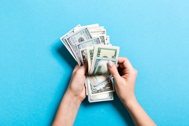 istock Top view of female hands counting money. Various banknotes on colorful background. Salary concept. Bribe concept 1177416708