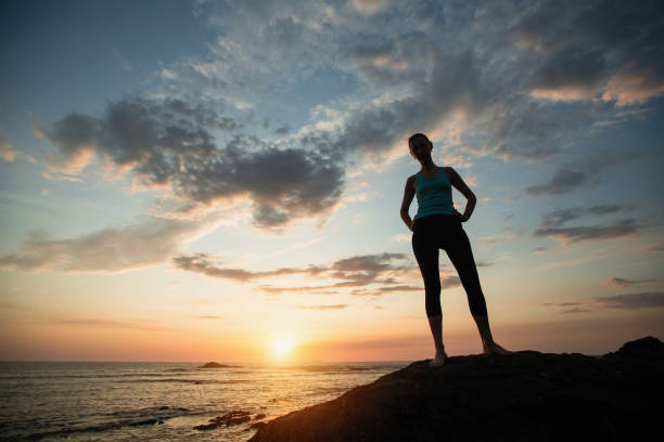 istock Young woman doing exercises on the ocean during sunset. 1177417439