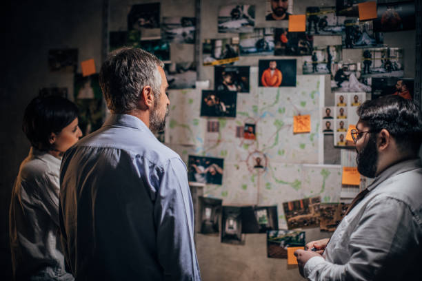 istock Three detectives looking for clues together in dark office 1177419662