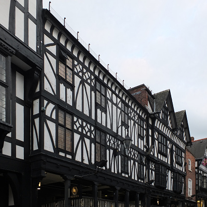 a row of ornate old half timbered gabled buildings in the historic city center of chester