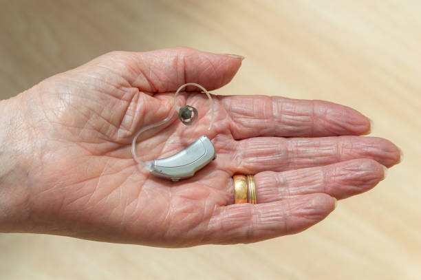 istock Behind The Ear hearing aid in pensioners hand. 1177422828
