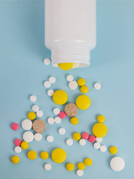 istock Several tablets fall out of the plastic jar on the surface. Background image on medical and pharmaceutical topics 1177422931