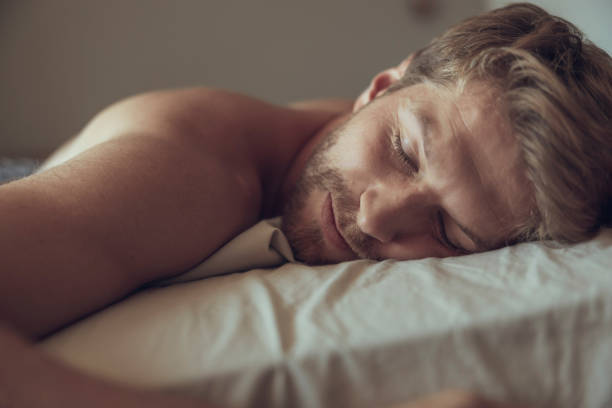 Young handsome man wearing shirt over isolated background sleeping tired dreaming and posing with hands together while smiling with closed eyes.