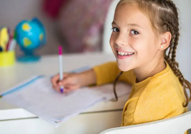 Photo of School girl studying at home