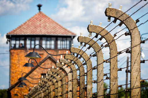 Auschwitz - Birkenau, Poland - August 11, 2019:The guard's watch tower and fence of barbed wire, Auschwitz - Birkenau concentration camp, Poland