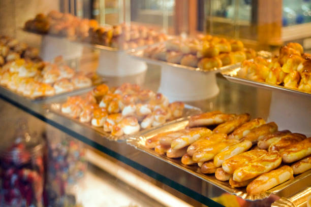 Bakery store window. Close-up view of two rows of trays full of Christmas spanish traditional cakes, marzipan, polvorones, turron. Santiago de Compostela, Galicia, Spain.