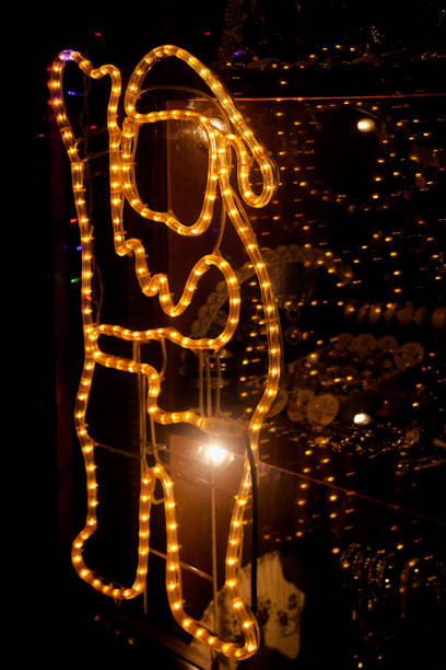 Santa Claus Silhouette, led light Christmas decoration. Dark background, store window retail display. Copy space on the right.