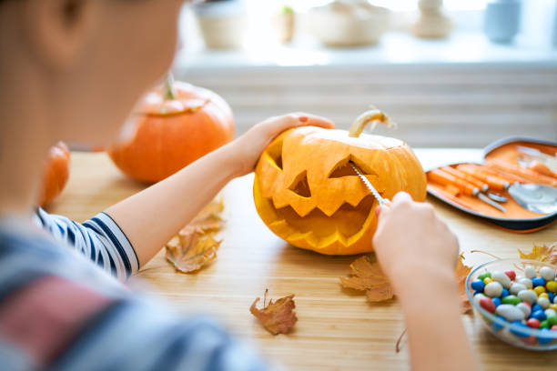 istock Woman is carving pumpkin 1177430309