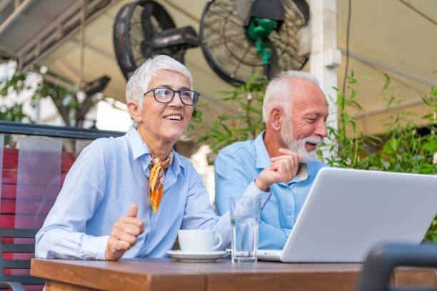 istock Two Older People in the City Restaurant Working with Laptop 1177430502