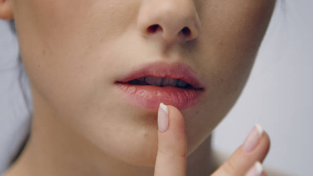 istock Delicate woman face skin care. Touching lips 1177432429