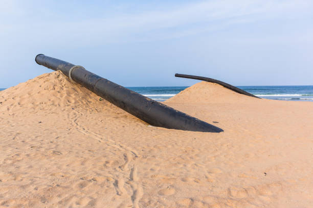 istock Large Black Pipe Industrial Equipment Beach Ocean 1177432514