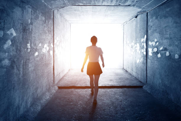 istock Woman walking through a dark tunnel 1177433024