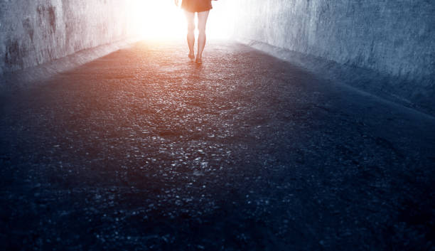 istock Woman walking through a dark tunnel 1177433052