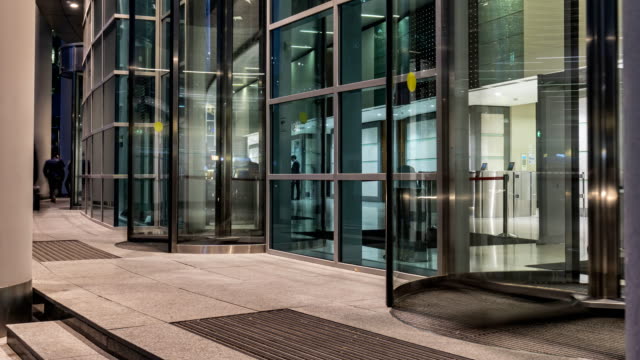 The flow of people passing through the revolving door of the modern office building at the end of the working day,time lapse