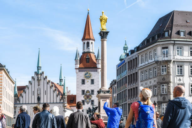 Munich, Germany - September 20, 2019: visitors and citizen of Munich at Marienplatz with old town hall under blue late summer sky