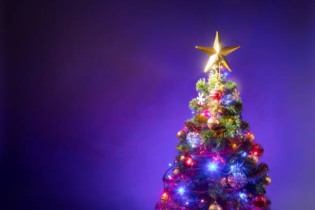 istock Christmas tree with festive lights, purple background 1177437929