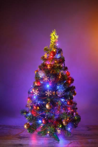 istock Christmas tree with festive lights, purple background 1177437955