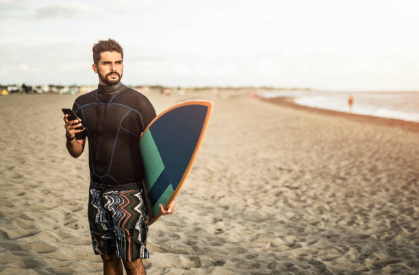 jeune surfeur sur la plage. - shorts rear view summer beach photos et images de collection