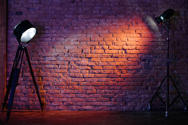 istock Old retro red brick wall being lit by a stage light bulb light. Constant light modifier projecting light on it 1177438001