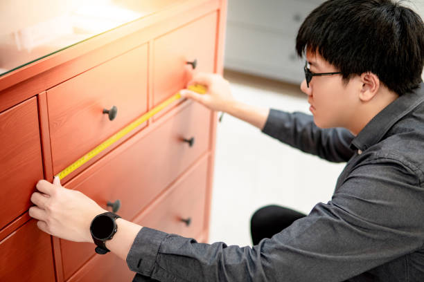 istock Asian man using tape measure on cabinet drawer 1177440338