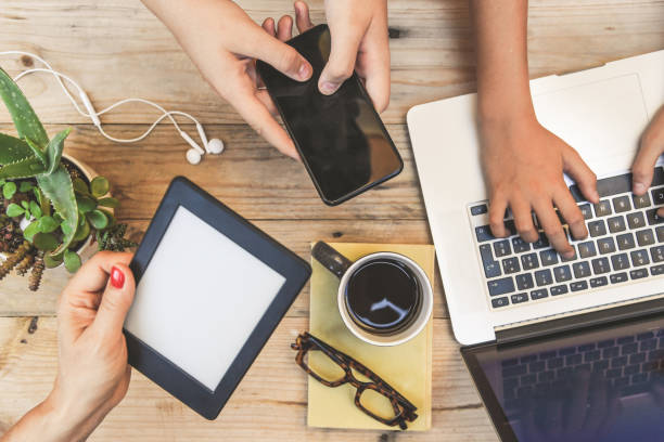 istock People using various devices wireless connected online. Notebook, ebook and cell phone communicate together. Top view of many hands  playing with new tech device. New communication technology concept. 1177440688