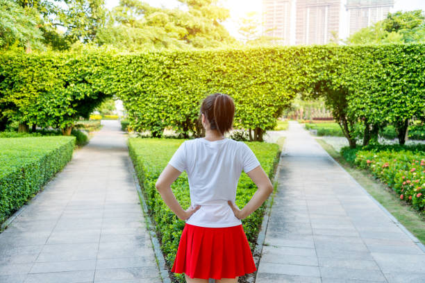 woman standing in front of forked road - women rear view one person arch imagens e fotografias de stock