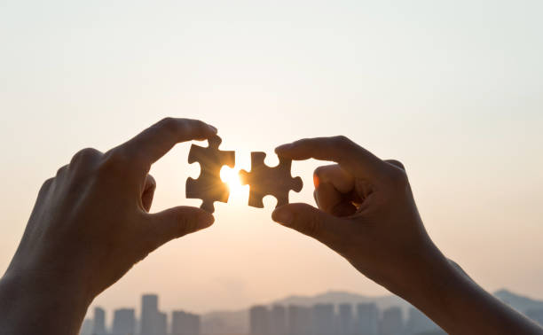 istock Woman hand putting puzzle pieces together in sunset 1177442407