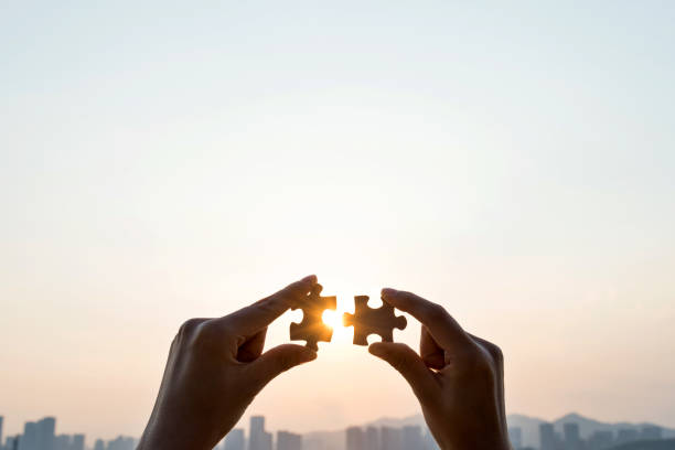 istock Woman hand putting puzzle pieces together in sunset 1177442663
