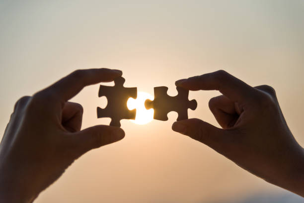 istock Woman hand putting puzzle pieces together in sunset 1177442776