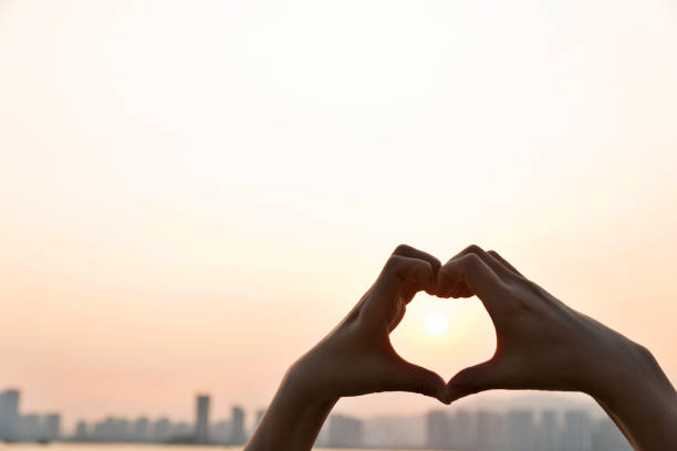 istock Woman hand make a heart shape in sunset 1177442836