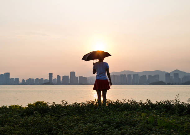 istock Woman standing on beach in sunset 1177442875