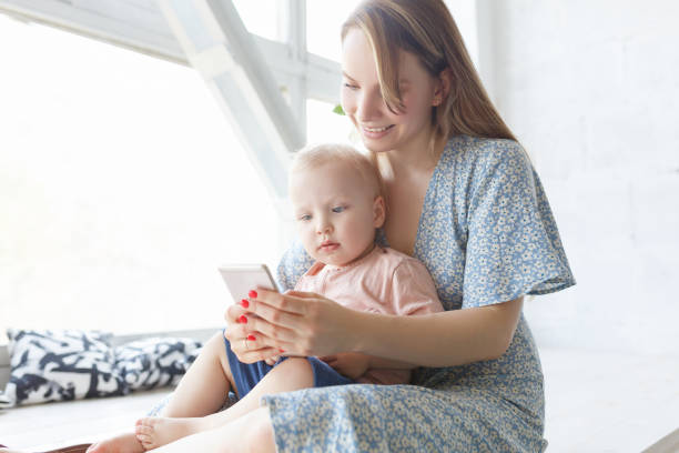 istock Young mom playing games or using app on smart phone 1177442901