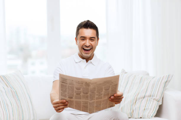 istock happy man reading newspaper and laughing at home 1177443866