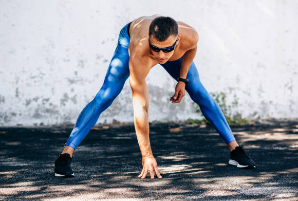 istock Muscular young man stretching before exercises outdoors against concrete wall. Athlete male stretches after workout outside. Sport and people concept. Copy space for your text 1177444091