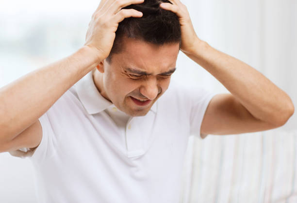 istock unhappy man suffering from head ache at home 1177444147