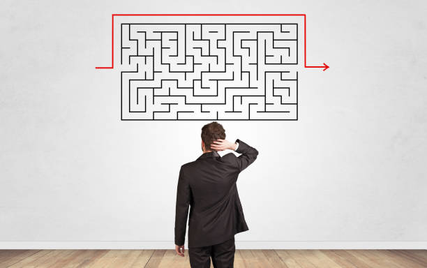 istock Businessman looking to a maze on a wall 1177444156