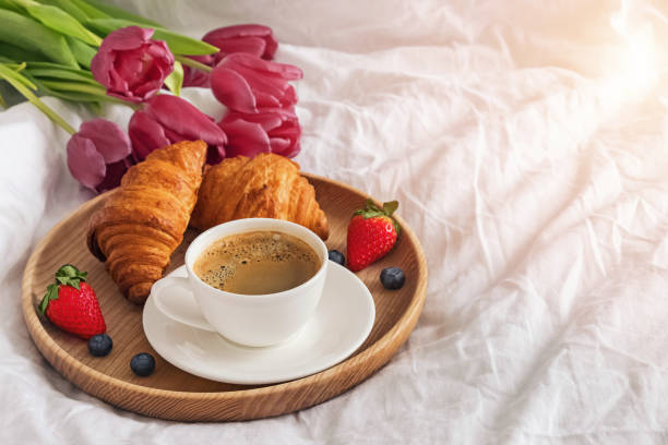 istock Coffee,croissants and flowers on the white bedsheets close-up 1177448533