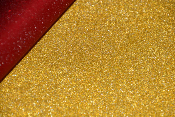 istock christmas bokeh gold shimmer with shining red backdrop 1177448619