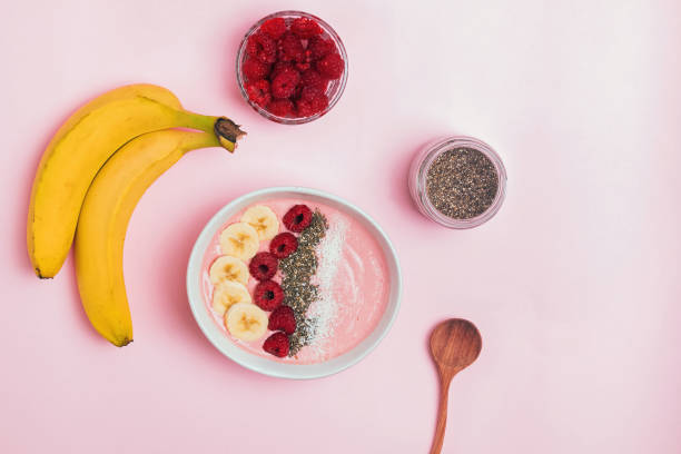 istock Smoothie bowl with bananas and raspberies on pink background 1177448654