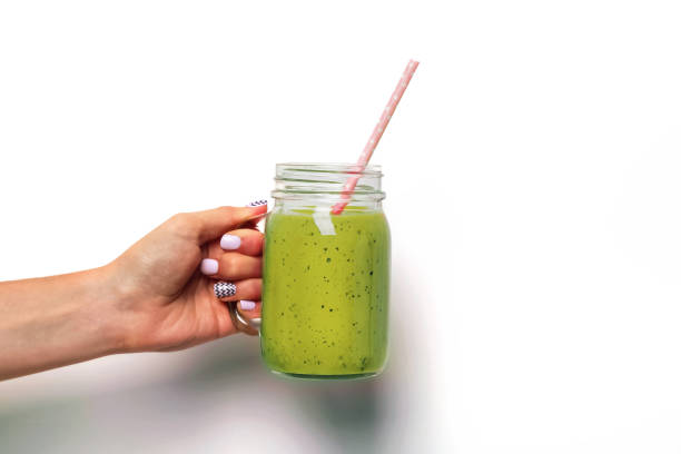 istock Woman's hand holding a glass jar with green smoothie 1177448741